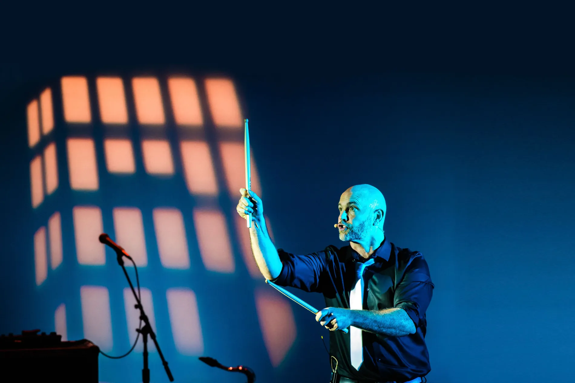 Bronkar Lee performing with drumsticks on stage