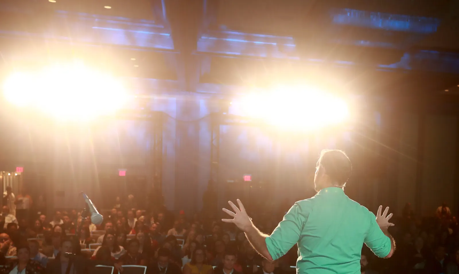 Bronkar Lee facing a live audience from the stage