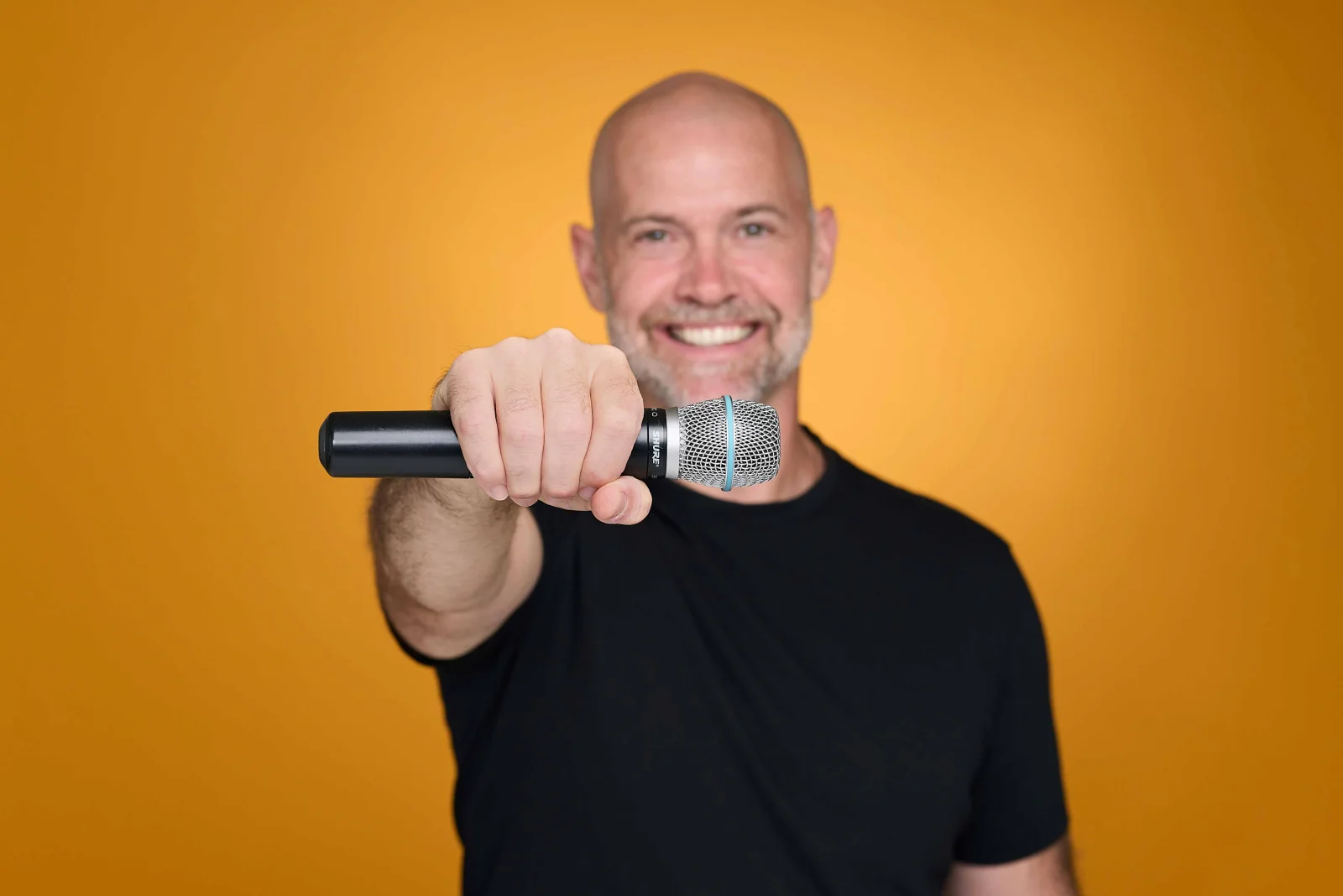 Bronkar Lee holding a microphone toward the viewer